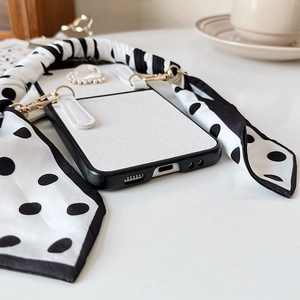 Detail of Galaxy Z Flip case with white twill texture and black polka dot silk strap