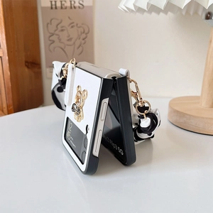 Macro detail of white leather case for Samsung Z Flip with golden bear and silk ribbon strap
