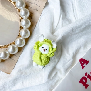 Macro detail of cute cabbage animal phone socket with transparent base on textured fabric