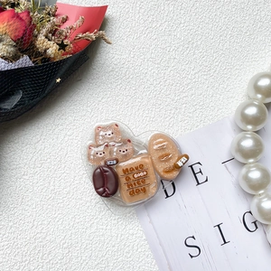 Detalle del soporte para móvil de corazón con miniaturas de café, pan y osos