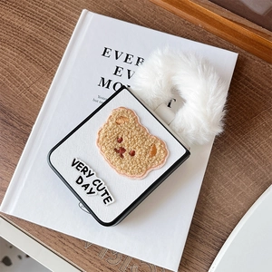 Détail de la broderie ours en peluche et anneau en fausse fourrure blanche sur la coque Z Flip
