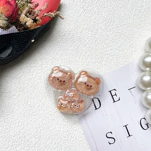 Detalle de soporte para móvil en forma de corazón con osos marrones y purpurina plateada