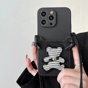 Detail of black leather iPhone case featuring a houndstooth bear card holder and crossbody strap