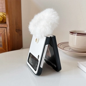 Détail de la coque Galaxy Z Flip avec design bicolore noir et blanc et pompon en peluche