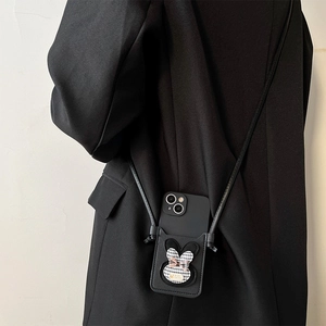 Close-up of black leather phone crossbody bag with rabbit ears and checkered bow detail