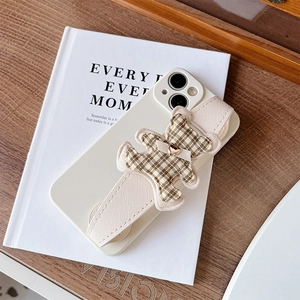 Detail of cream iPhone case with woven wrist strap and plush plaid bear decoration