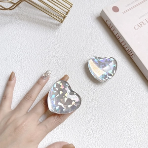 Iridescent laser heart phone socket mount with colorful resin glitter on white background