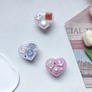 Heart-shaped collapsible phone socket with pink gems, pearls, and Love lettering