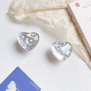 Detail of two translucent heart-shaped phone grips with iridescent holographic flakes
