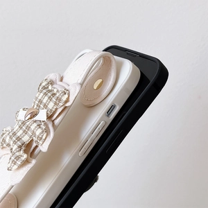 Detail of cream leather case with bear charm and functional wrist strap for iPhone