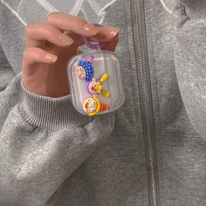 Handheld transparent AirPods case featuring 3D colorful clown dolls and purple hook