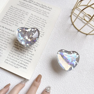 Iridescent crystal heart phone socket with laser cut texture on stylish magazine background