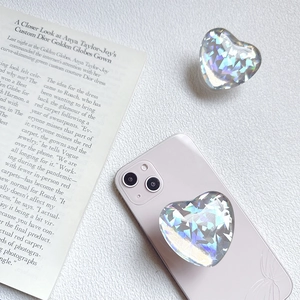 Close-up of heart-shaped holographic phone grip with iridescent laser design on pink phone