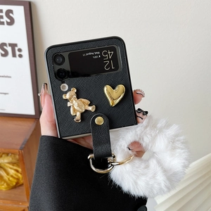 Detail of luxury plush pompom and gold bear charm on Z Flip 4 leather texture case