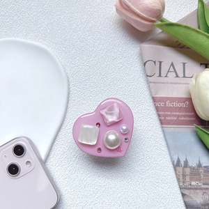 Close-up of heart-shaped phone grip with pink gems, white pearls and LOVE text