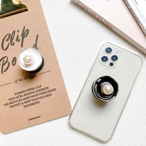 Close-up of elegant flower metal phone grip with white pearl on a transparent case