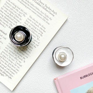 Detail of luxury flower phone grip with black and white enamel and central pearl inlay