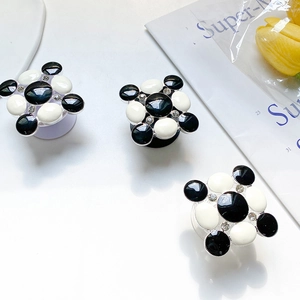 Close-up of black and white checkered phone griptoks with sparkling rhinestone accents