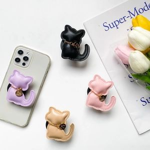 Detail of leather cat-shaped phone sockets in multiple colors with golden chain charms