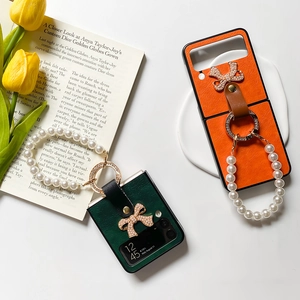 Vue détaillée de la coque Z Flip6 en cuir avec poignée en perles et nœud décoratif