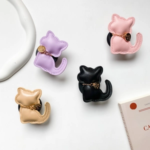 Cat-shaped leather phone socket stand in four colors with stitching and gold chain details