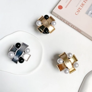 Detailed view of metal X-shaped phone grips with pearls and beads in a lifestyle setting