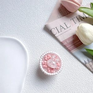 Detail of cute 3D pink rabbit phone grip with bowknot and pearls on white background