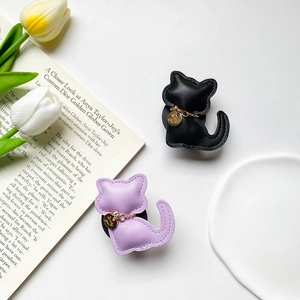Detail of leather cat phone sockets in black and purple with gold Lucky charms