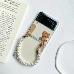 Detail of Galaxy Z Flip 6 case featuring a luxury pearl chain and 3D bear charm