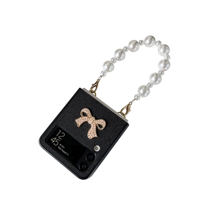 Samsung Galaxy Z Flip case with black texture, diamond bow, and white pearl strap