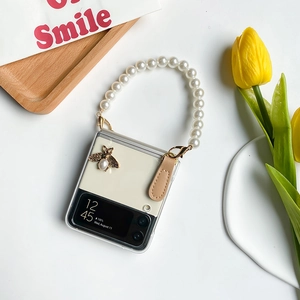 Detail of Samsung Z Flip6 case with pearl handle and golden bee embellishment
