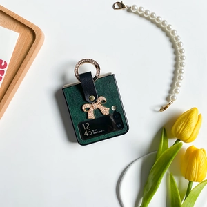 Détail de la coque Galaxy Z Flip 6 avec nœud en perles et texture cuir vert foncé