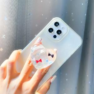 Transparent heart-shaped phone grip with mini bows attached to a white smartphone