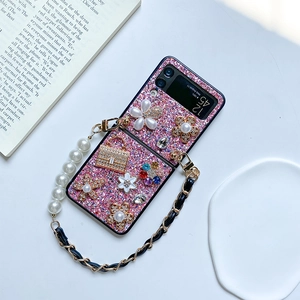 Detail of pink glitter phone case with pearl flower, rhinestones and metal chain strap