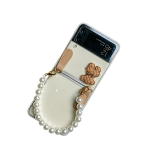 Samsung Galaxy Z Flip 6 clear case with cream bear ornament and pearl hand chain