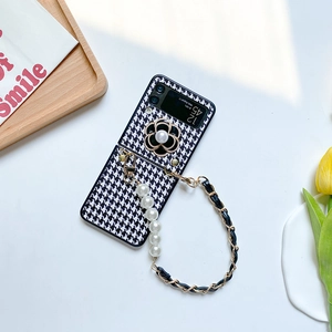 Detail of Galaxy Z Flip case featuring houndstooth pattern, camellia and pearl chain