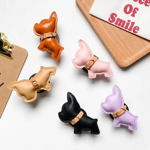 Foldable leather bulldog phone grip socket in five colors on a minimalist desk background