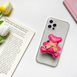 Detail of pink faux leather bear phone grip with bow on transparent phone case