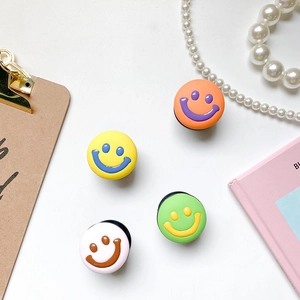 Flat lay of colorful 3D smiley face phone sockets with stylish lifestyle accessories