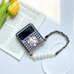 Detail view of houndstooth phone case for Galaxy Z Flip with camellia pearl and strap