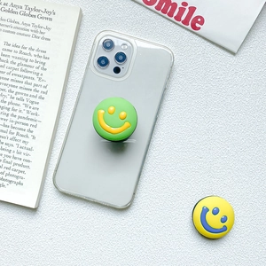 Close-up of colorful smiley face phone socket grips on a clear mobile phone case