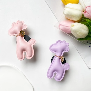 Detail of pink and purple giraffe phone grips with leather stitching and gold charms