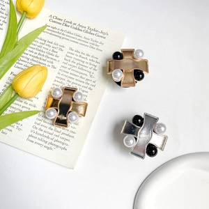 Cross-shaped mobile phone socket with pearls and vintage metal finish on a magazine background