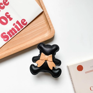 Detail of cute black bear phone socket with cream bow and premium stitched leather finish