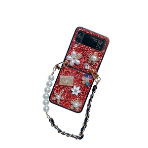 Red glitter Galaxy Z Flip6 case with luxury floral charms and pearl chain strap