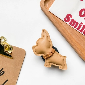 Close-up of khaki leather bulldog phone socket stand with decorative white stitching