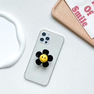 Transparent phone case with a black flower-shaped airbag grip featuring a yellow smiley face