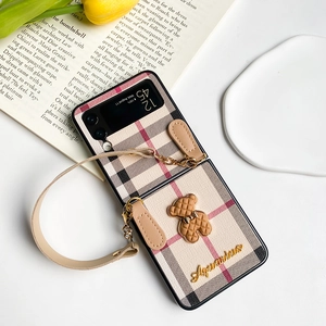 Detail of Galaxy Z Flip4 case with vintage plaid bear ornament and leather strap