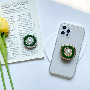 Vintage pearl phone grip with retro green enamel and metallic plating on a phone case