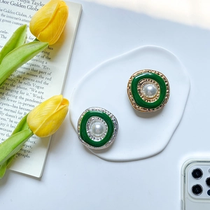 Macro shot of retro electroplated gold and silver frames with green enamel and pearls